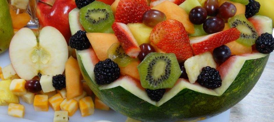A colorful bowl of fresh-cut fruit served with cheese